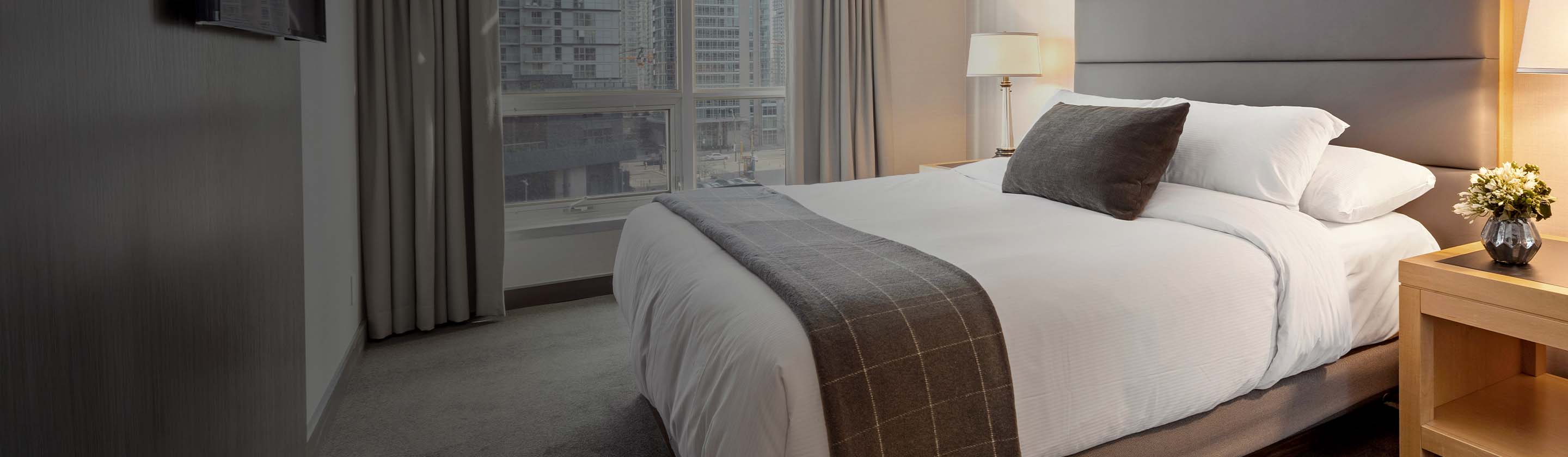 Modern hotel bedroom with a cityscape view.